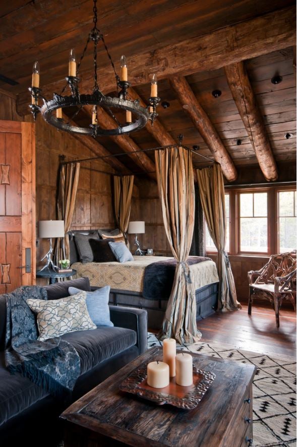 Apuesta por un dormitorio de inspiración medieval con una cama alta con dosel, madera como material protagonista y textiles nobles como el terciopelo, como en esta propuesta de Yellowstone Tradition (Imagen cortesía de Houzz.es).