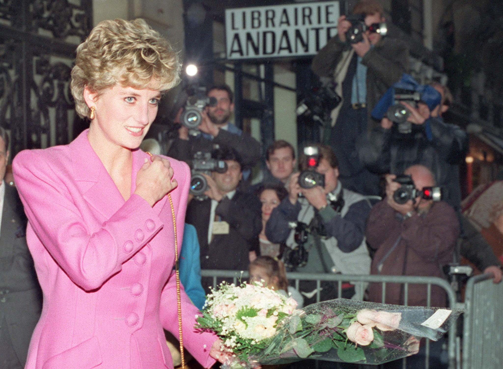 Diana de Gales en un acto oficial. Lleva un ramo de flores y luce una chaqueta en color rosa.