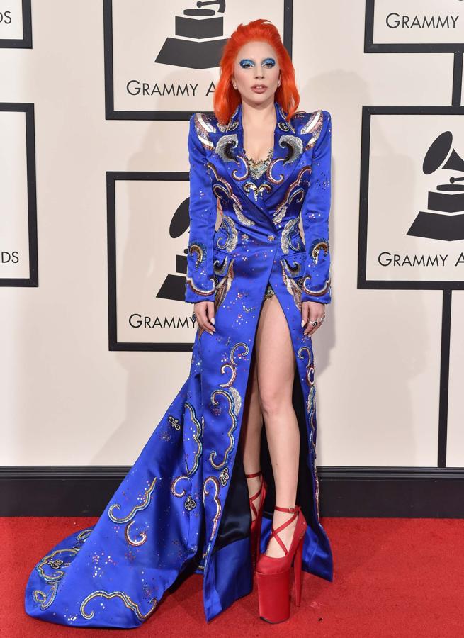 La cantante Lady Gaga en la gala de los Grammy´ 16. Lleva un vestido azul largo con una impresionante apertura en la parte delantera y unas plataformas en color rojo.