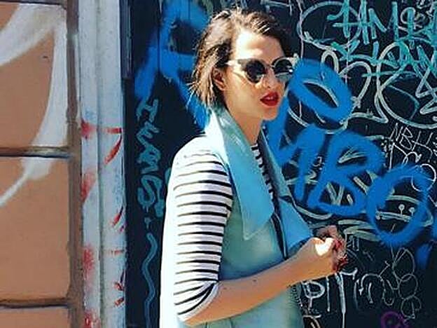 Madina Visconti di Madrone posando en la calle con un chaleco azul.