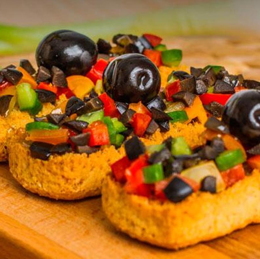 Tosta de pan integral con aceitunas hojiblanca negras, pepino, pimiento rojo, cebolleta y tomates cherry. Aliña con aceite de oliva virgen extra.