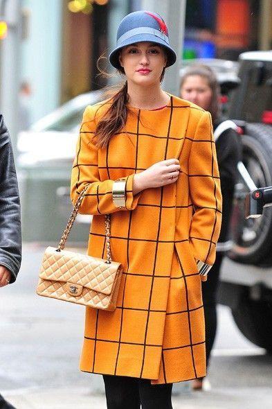 El abrigo de cuadros amarillo (tono tendencia), un sombrero tipo 'vintage' (el complemento de moda) y un atemporal 2.55 de Chanel. Este look nos sentaría bien a cualquiera... en cualquier momento.
