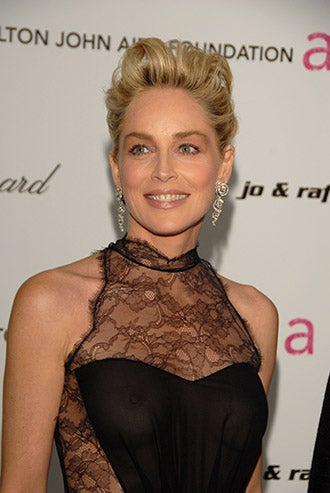 Sharon Stone en la gala de la Fundación de Elthon John. Lleva un vestido de encaje con una parte de tela rasa con transparencias.