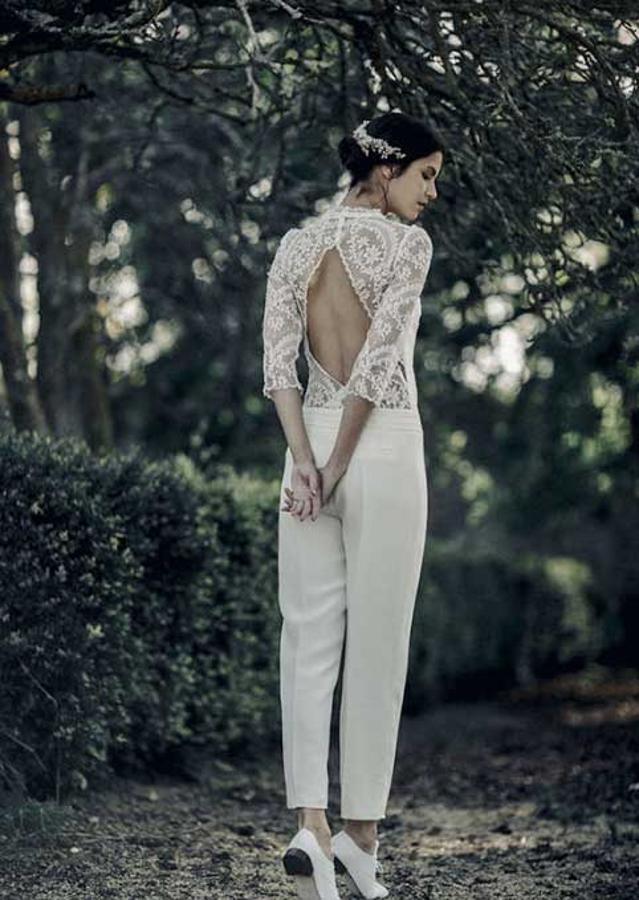 Pantalón de pinzas, cuerpo de encaje con manga tres cuartos y espalda descubierta.