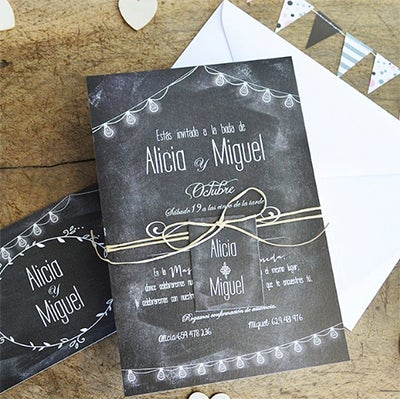 Invitación de boda rectangular de colores blanco y negro, simulando una pizarra, las bombillas tienes un ligero barniz brillo. Acompañada de una etiqueta rectangular con vuestros nombres. La etiqueta van enlazada a la invitación mediante una fina cuerda natural.