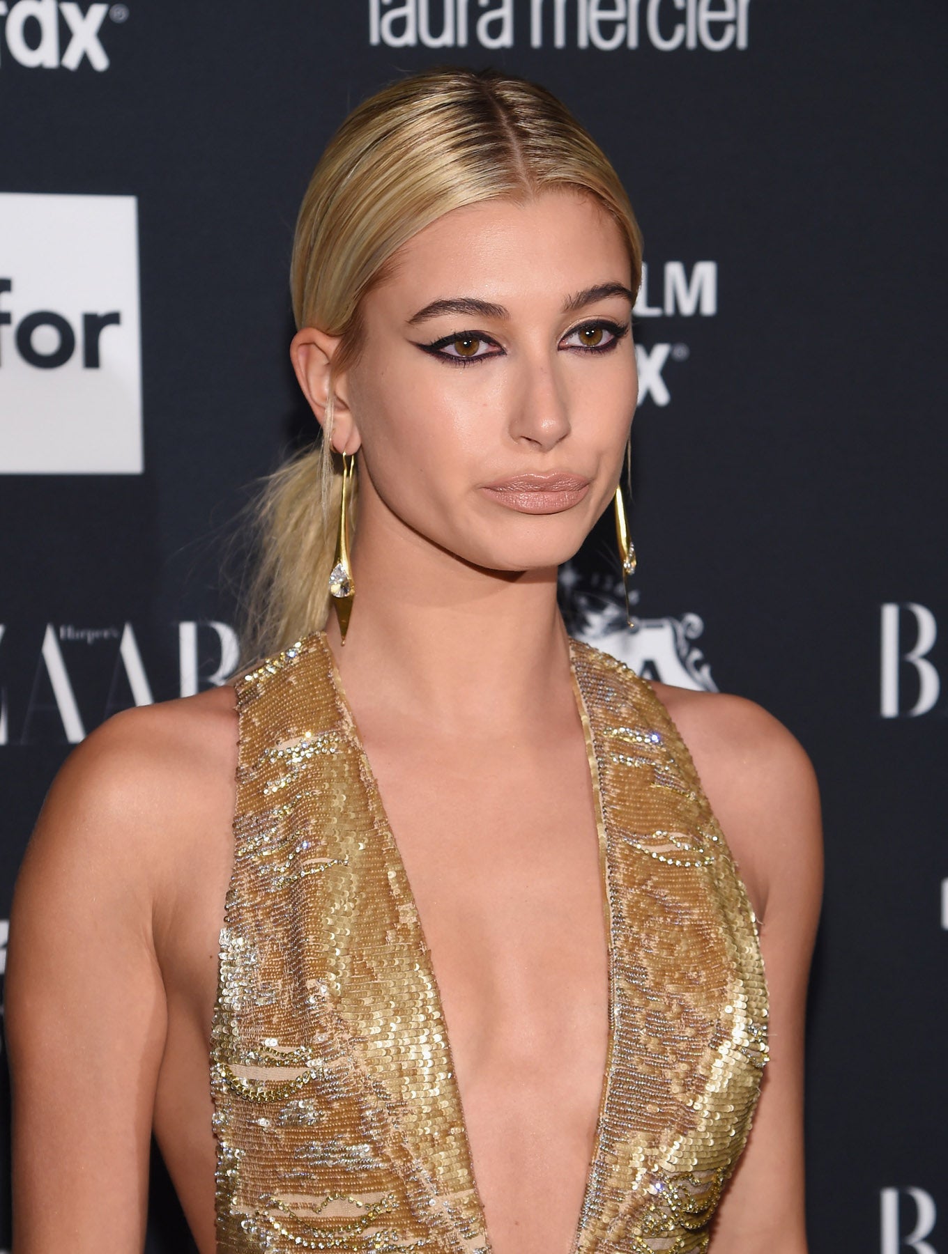 El 'cat eye' o maquillaje ojos de gata con eyeliner negro y un poco de máscara de pestañas es un look muy sexy como nos demuestra la top Hailey Baldwin, que lo combina con labios nude semimates.