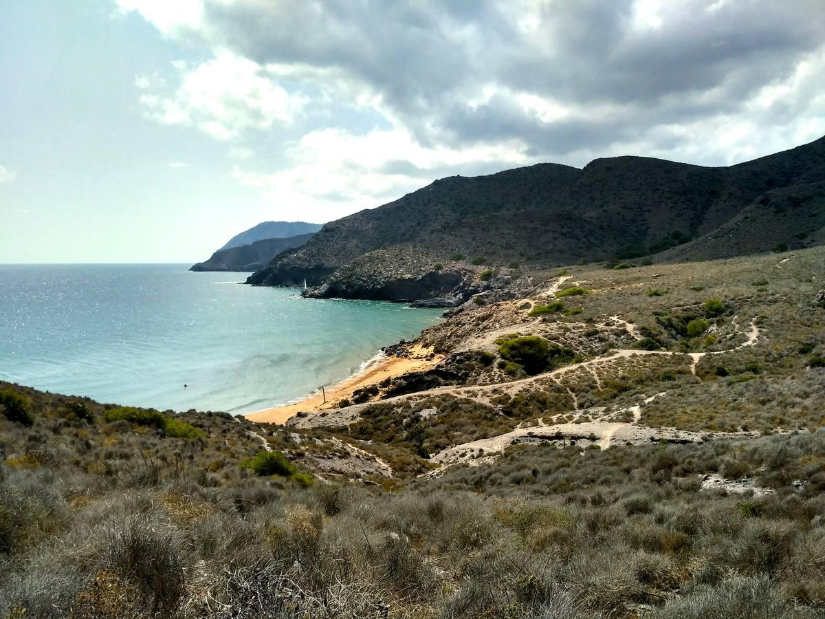 De gran valor paisajístico y situada en el Parque Regional de Calblanque, es una de las playas naturales de España a las que viajar en 2017. Largas playas de arenas ocres, blancas salinas y solitarias calas contrastan con los macizos montañosos que la rodean. Para proteger este espacio y promover la movilidad sostenible, cada lunes de septiembre no se permite el acceso de vehículos de motor.