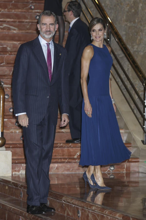 Aunque en las últimas ediciones la reina Letizia siempre había apostado por el negro, esta vez la reina se decantó por el azul. En el concierto de los Premios Princesa de Asturias 2017 derrochó estilo con un vestido de largo midi y botonadura trasera que firmaba Felipe Varela, su diseñador predilecto para las grandes ocasiones. Completó el look con unos pendientes chandelier de Yanes, de diamantes y topacios, unos braceletes de Cartier y salones de Nina Ricci.