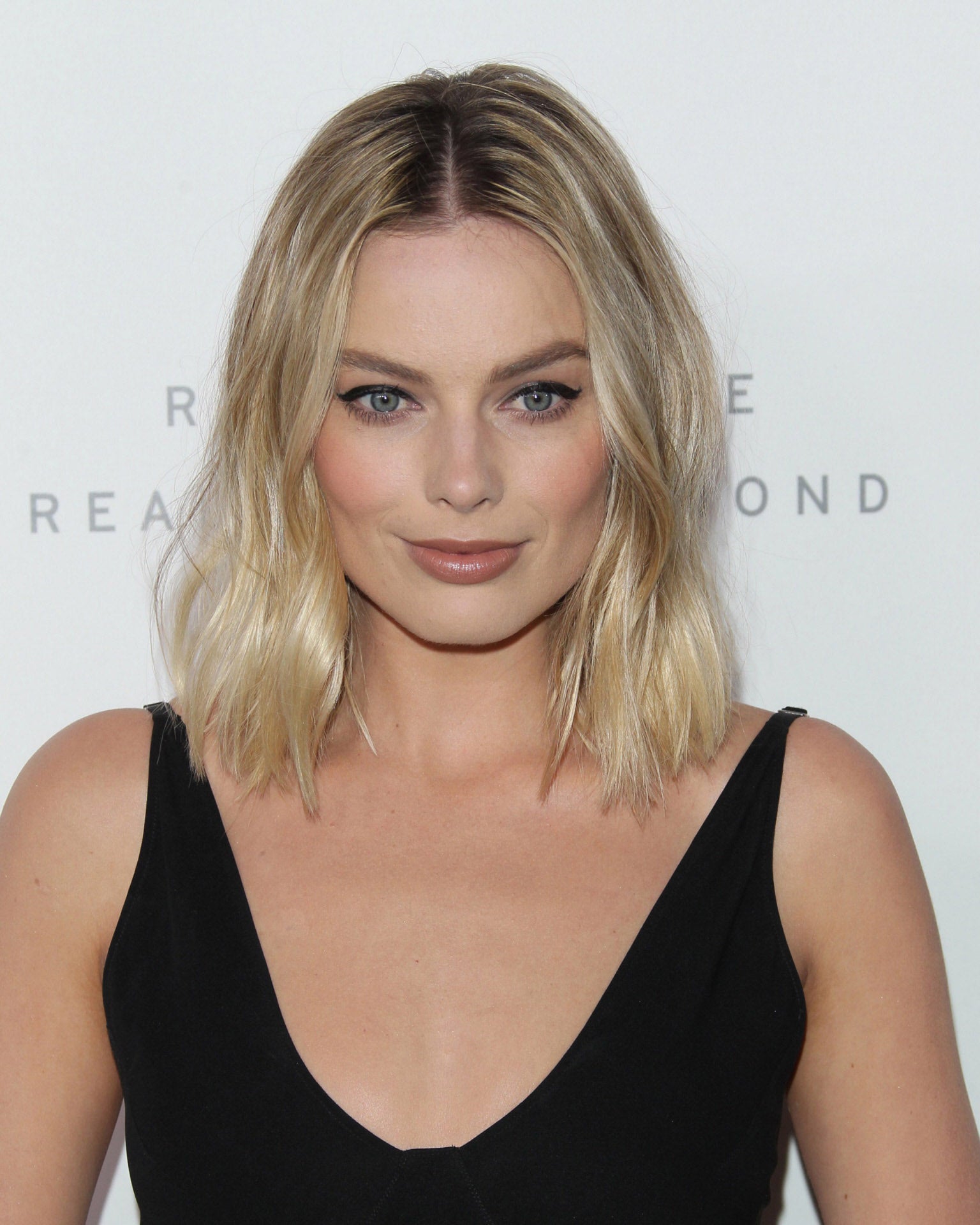Algo más discretas son las raíces oscuras que luce la actriz Margot Robbie en su media melena rubia.