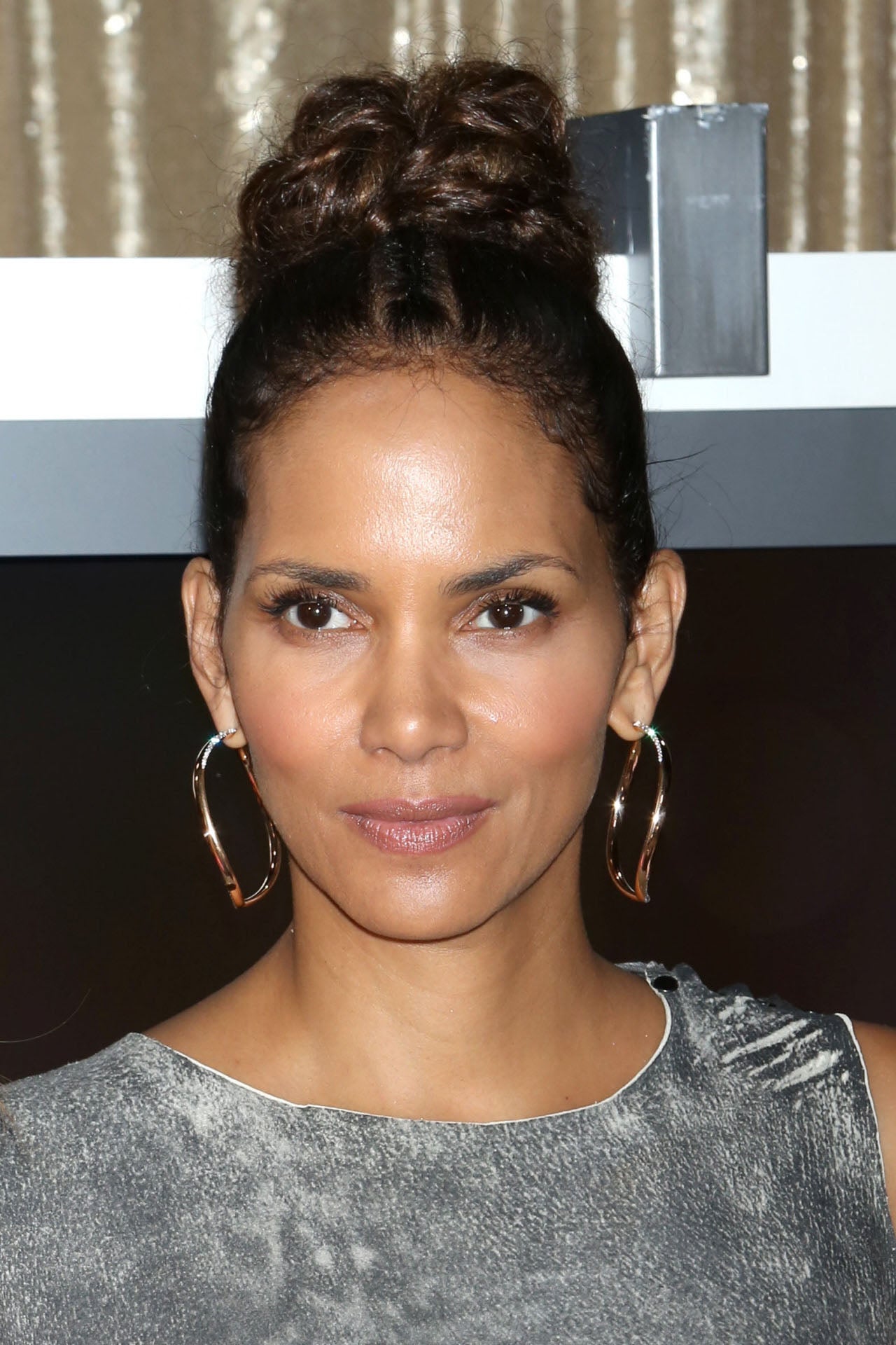 El moño alto es uno de los peinados más estilosos para lucir los pendientes XXL, poco más necesitarás para estar perfecta como demuestra Halle Berry.
