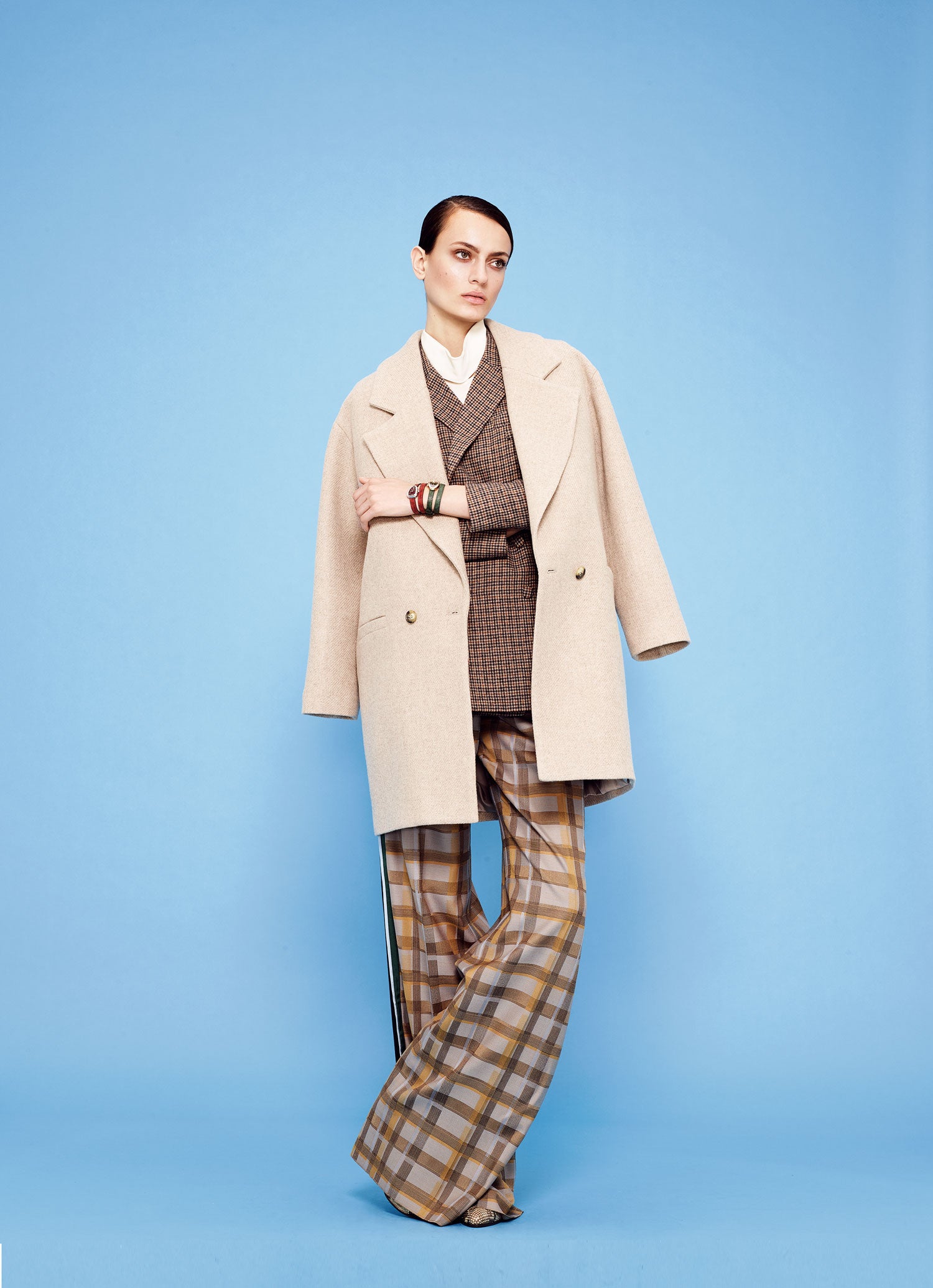 Debajo de un abrigo de Trucco, chaqueta cruzada de Intropia y camisa de Theory. Pantalón de cuadros, de Hermès. Los relojes son el modelo Serpenti de Bulgari.