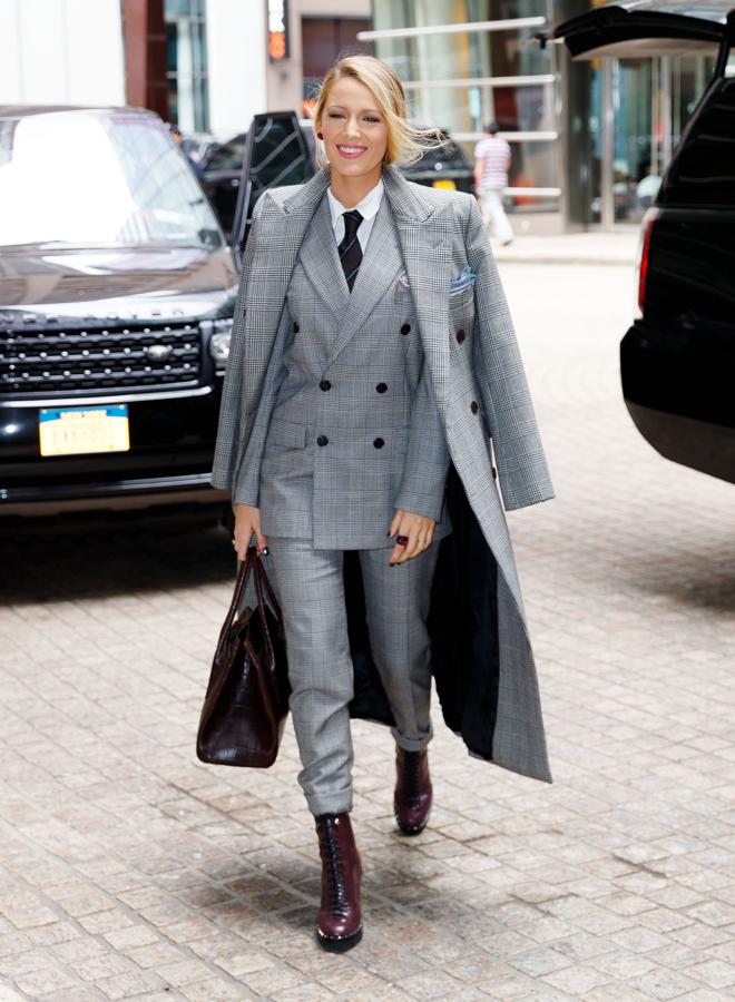 Blake Lively se vistió de working girl con un traje masculino y abrigo a juego con estampado príncipe de Gales y botines de tacón de Ralph Lauren y bolso de Michael Kors.