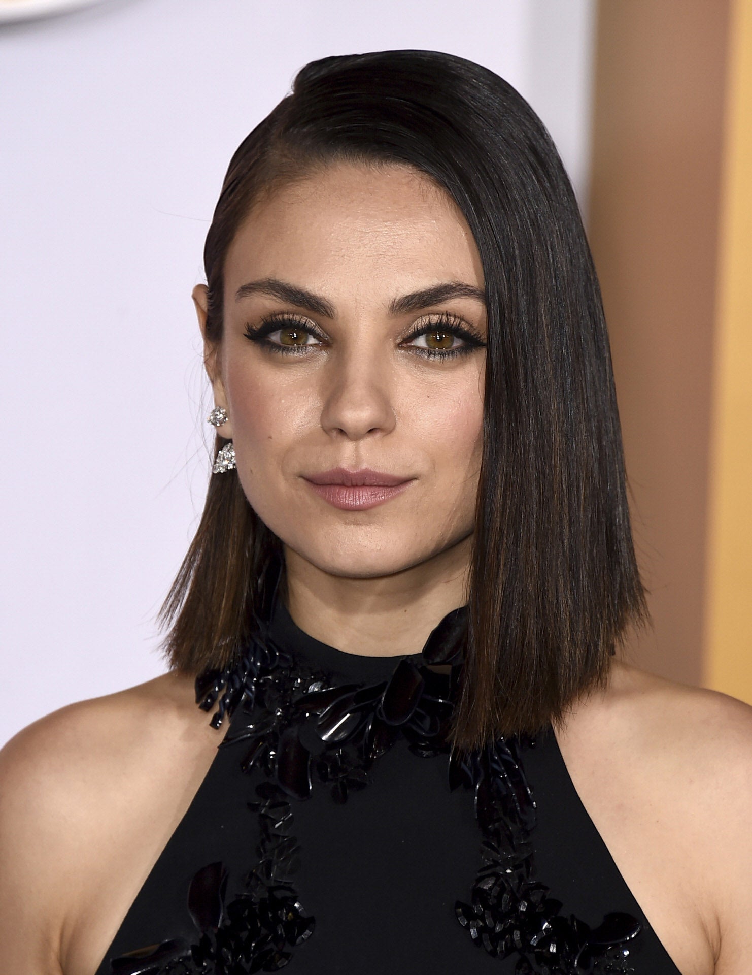 Mila Kunis con long bob recto, peinado con raya a un lado.