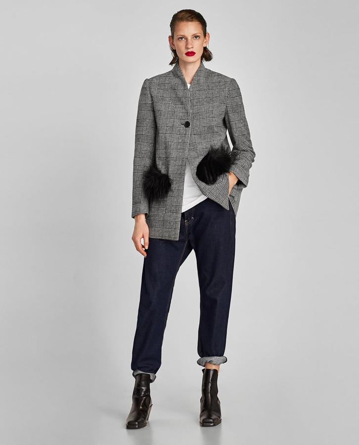La chaqueta príncipe de Gales de Zara tiene los apliques de piel en los bolsillos en vez de en las mangas, y está rebajada de 49.95 a 29.99 euros.