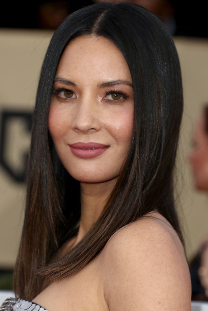 Olivia Munn con el pelo liso y raya en el medio y un maquillaje muy discreto con labios rosas mates y sombras glitter en tono nude.
