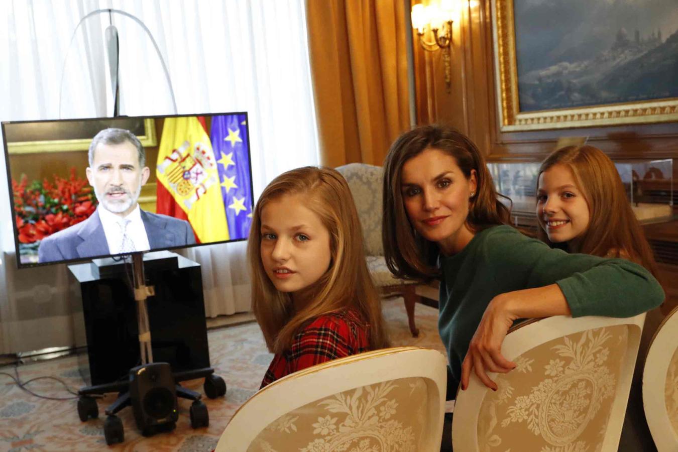 Doña Letizia, la Princesa Leonor y la Infanta Sofía con el discurso de Navidad de don Felipe de fondo.