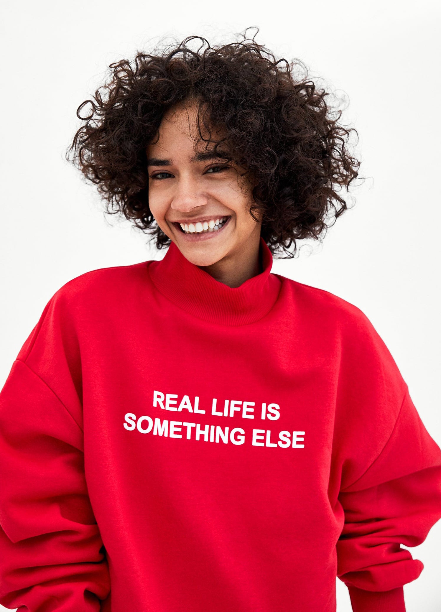 Bob con rizos ochenteros y raya en el medio.