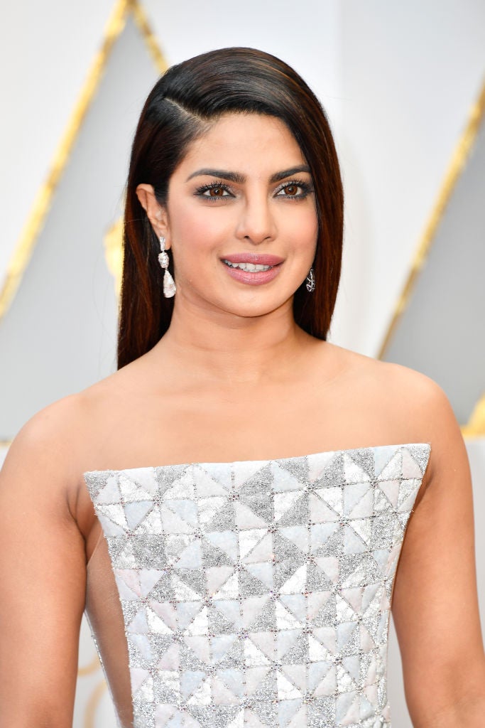 Priyanka Chopra con melena extra lisa y raya lateral baja en los Oscar 2017. En su maquillaje destaca el ahumado en tonos grises de los ojos.
