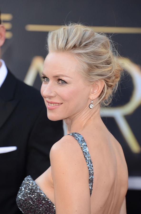 Naomi Watts en los Oscar 2013 con recogido efecto 'messy' y volumen en las raíces y maquillaje en tonos rosas.