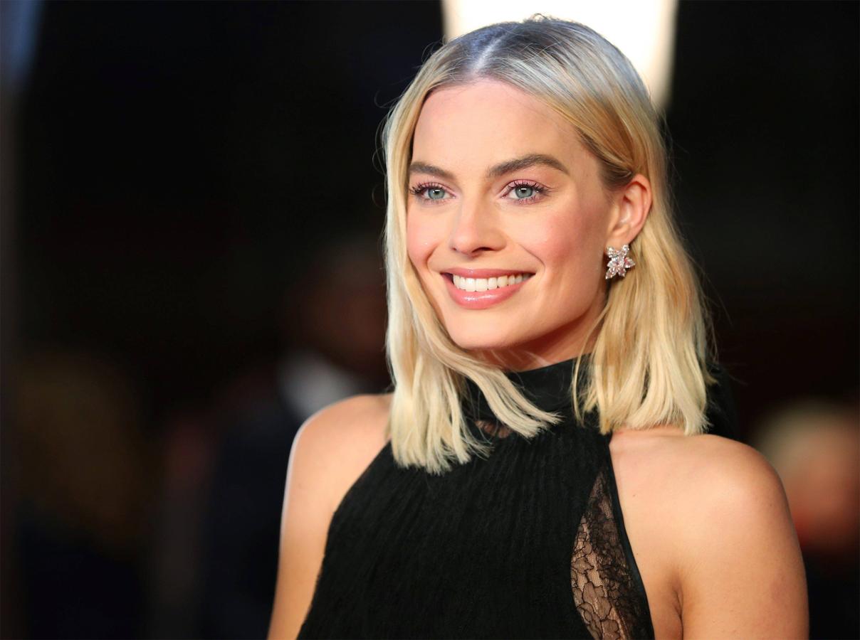 Margot Robbie lució su media melena suelta con ondas rotas y raya en el medio. Su maquillaje fue muy natural: en tonos rosas y labios con gloss.