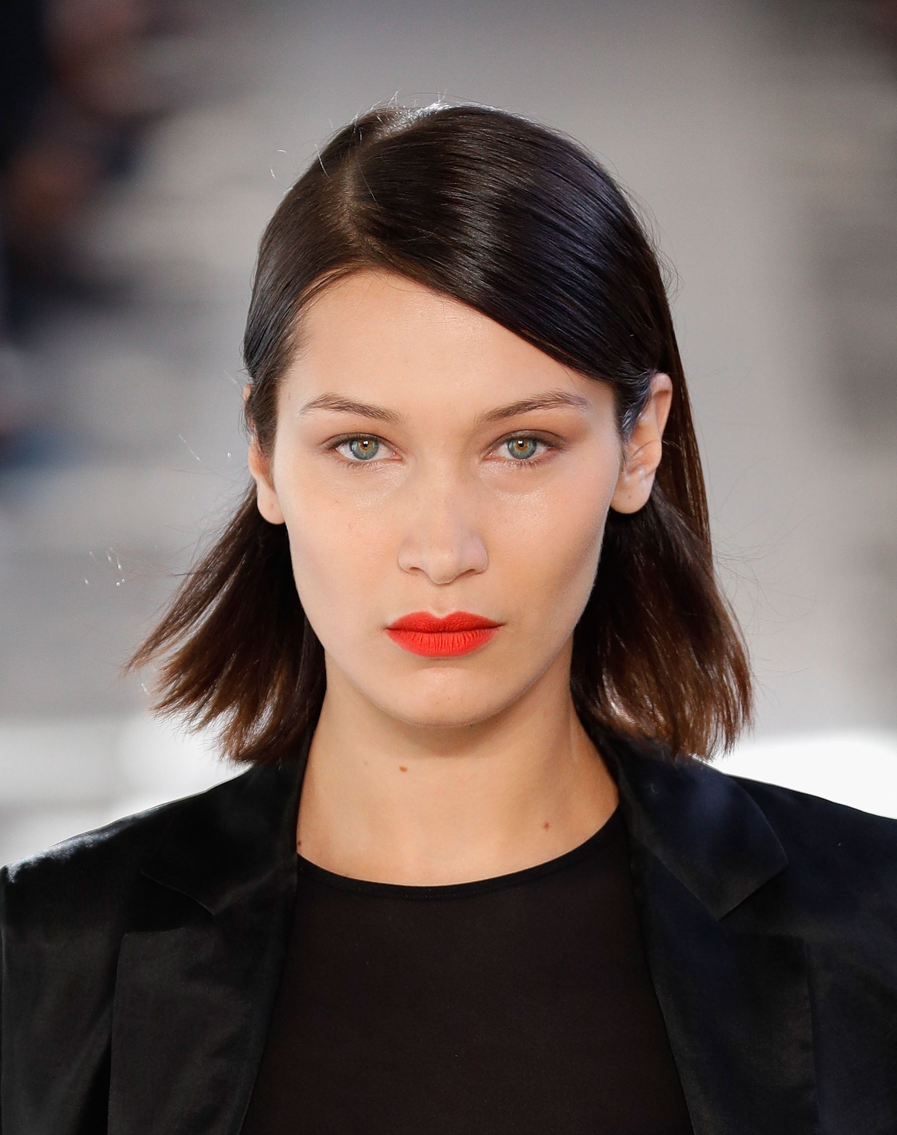 Bella Hadid con bob liso, peinado con raya a un lado, acabado 'wet' en las raíces y metido detrás de las orejas.