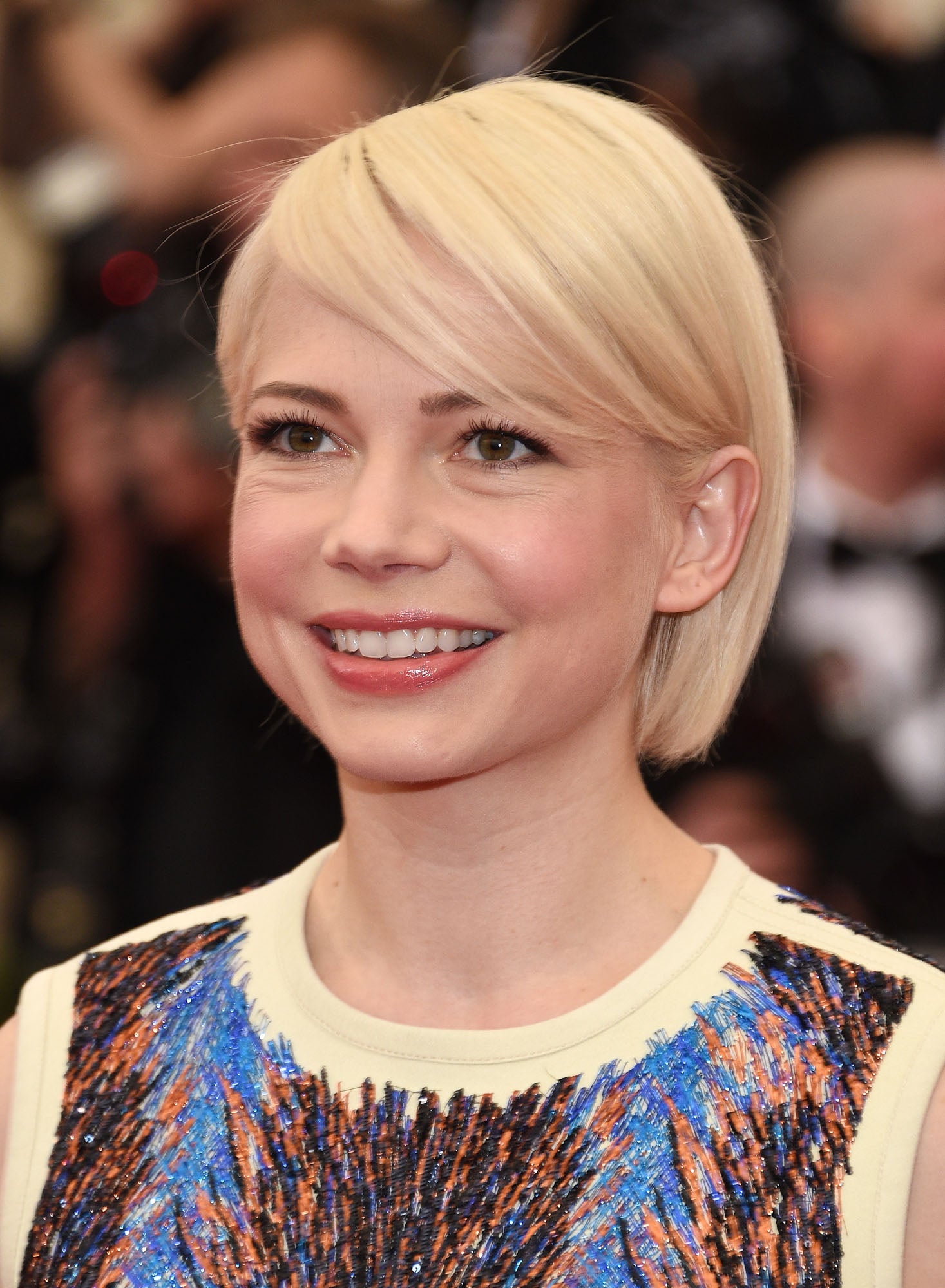 Michelle Williams con el pelo liso corto, peinado con raya a un lado y flequillo lateral.