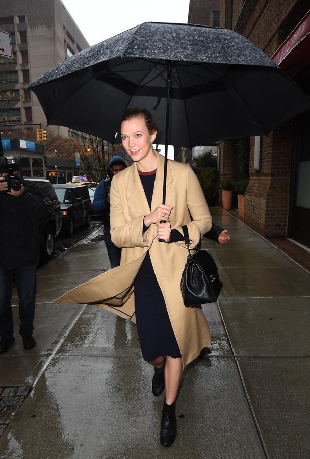 Karlie Kloss nunca pierde su estilo. Su abrigo, perfectamente conjuntado con vestido midi y botines bajos, nos encanta. ¡Y poco se habla del paraguas tan grande que lleva!