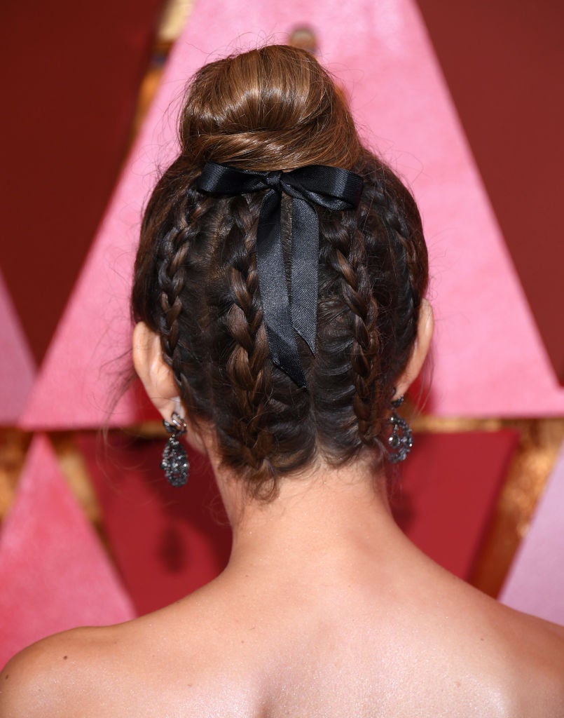 El peinado de Maria Menounos en los Oscar 2018: mini trenzas invertidas que acaban en un moño alto o 'top knot' adornado con un lazo negro. ¡Nos encanta!