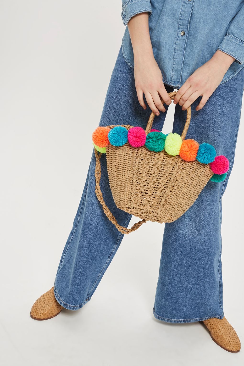 Cesta con pompones de lana de colores de Topshop. Precio: 32 euros.