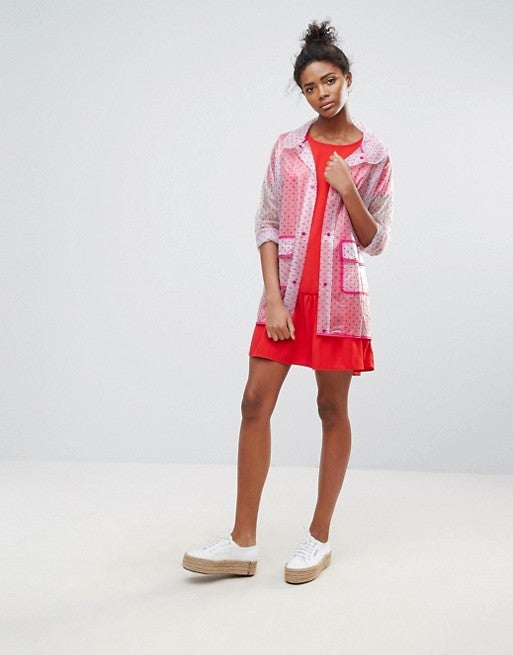 Qed London apuesta por un toque 'naive' con este chubasquero transparente con estampado 'dotty' (24.99 euros en Asos).