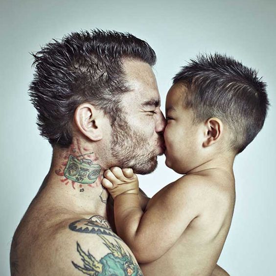 Un papá y su hijo dándose un beso. Para que luego digan que los papás tatuados son chicos duros...