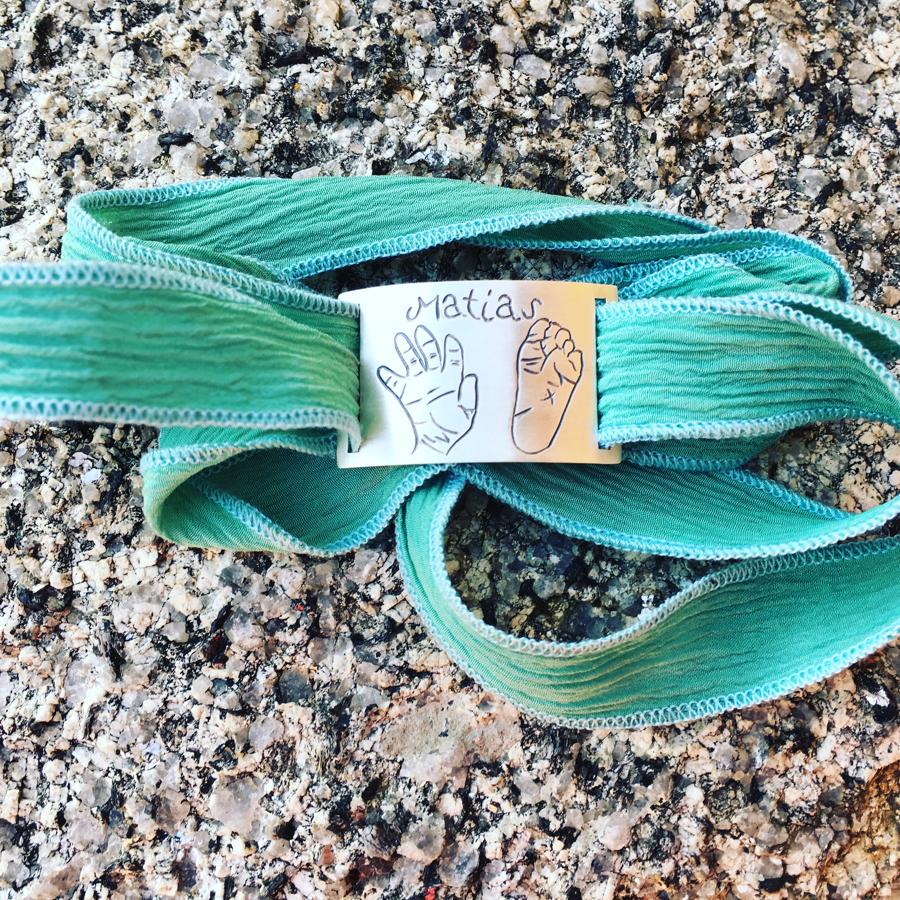 Puedes personalizar una esclava de plata con una reproducción del dibujo de los pies y las manitas del bebé. En  Midibu4u.es  te explican cuál podrías ser la mejor opción y podrás escoger entre dos tipos de cinta, de seda natural pintada a mano o elástica con un toque más informal.