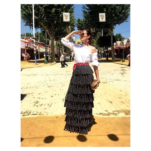 Combinó una flada de lunares y volantes con una camisa blanca asimétrica y remató el look con un pañuelo en la cintura de lunares rojos.