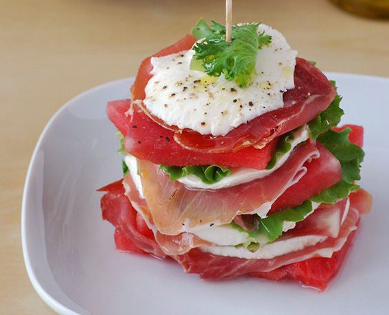 Milhojas de sandía, jamón serrano, queso mozzarella y lechuga.