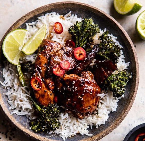 Arroz con pollo teriyaki y sésamo acompañado de brócoli.