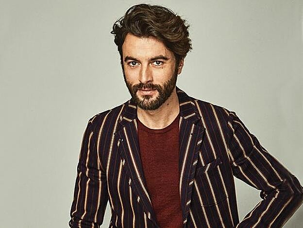 Javier Rey lleva sastre y jersey de Salvatore Ferragamo.