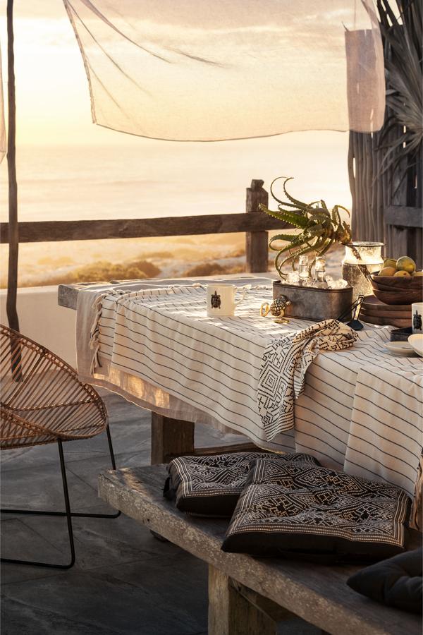 Los tejidos y colores naturales, adornados con pinceladas étnicas de esta terraza con vistas que nos proponen desde H&M Home son un auténtico acierto.