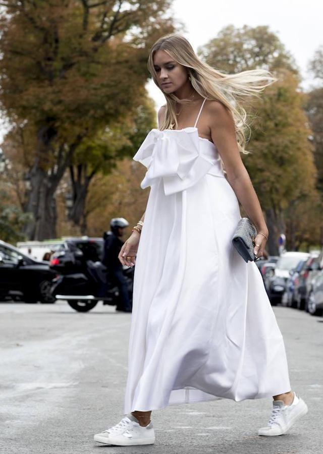 Un maxi vestido blanco, amplio, combinado con zapatillas para un estilismo 'casual chic'.