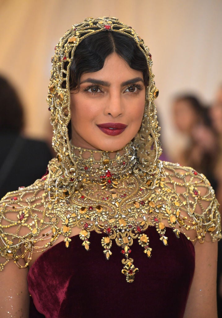 Priyanka Chopra ha optado por una mantilla dorada con piedras, debajo de la cual adivinamos un recogido con ondas retro.