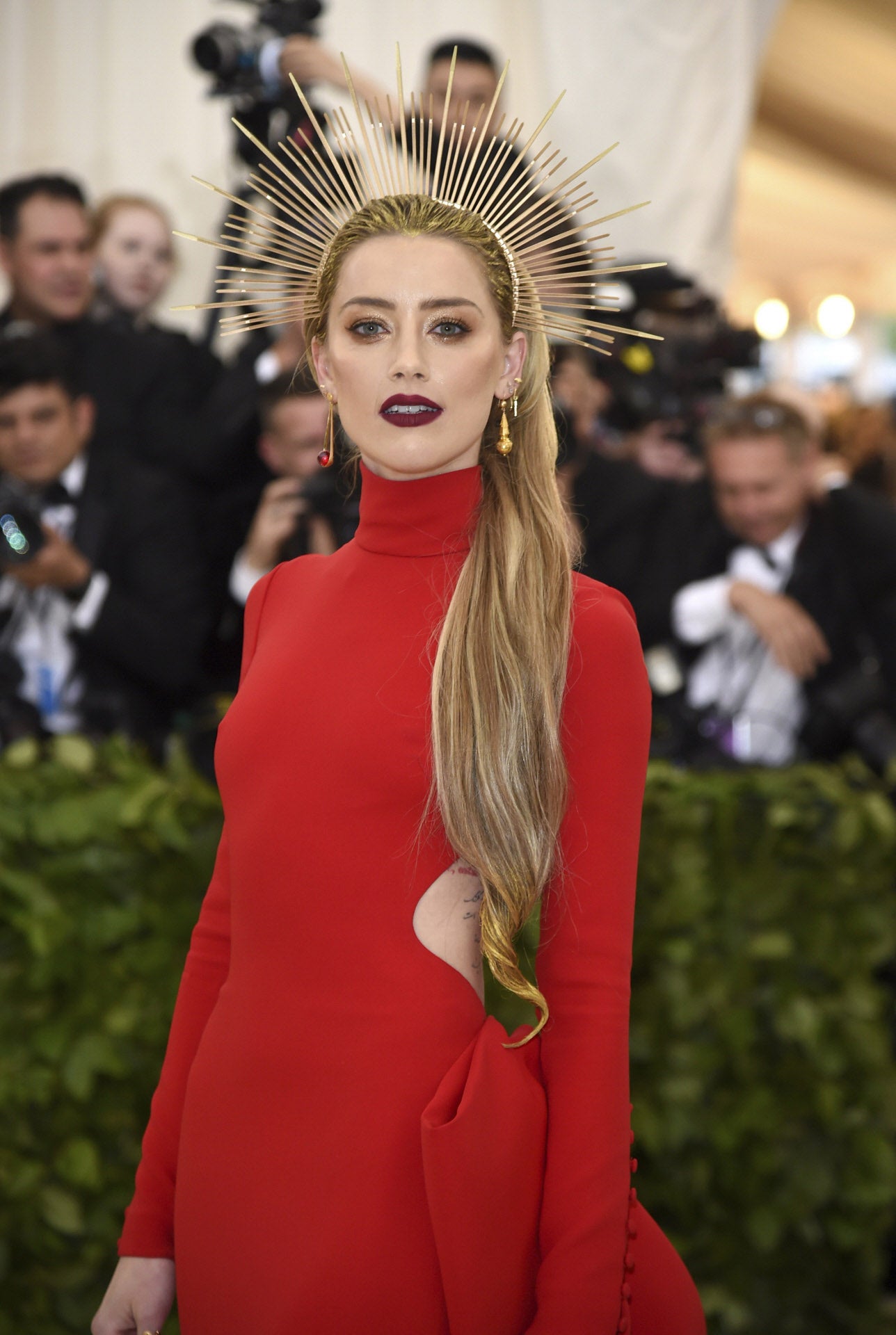 La actriz Amber Heard ha adornado su melena suelta lisa con una corona de espinas dorada, nos encanta la purpurina del pelo.