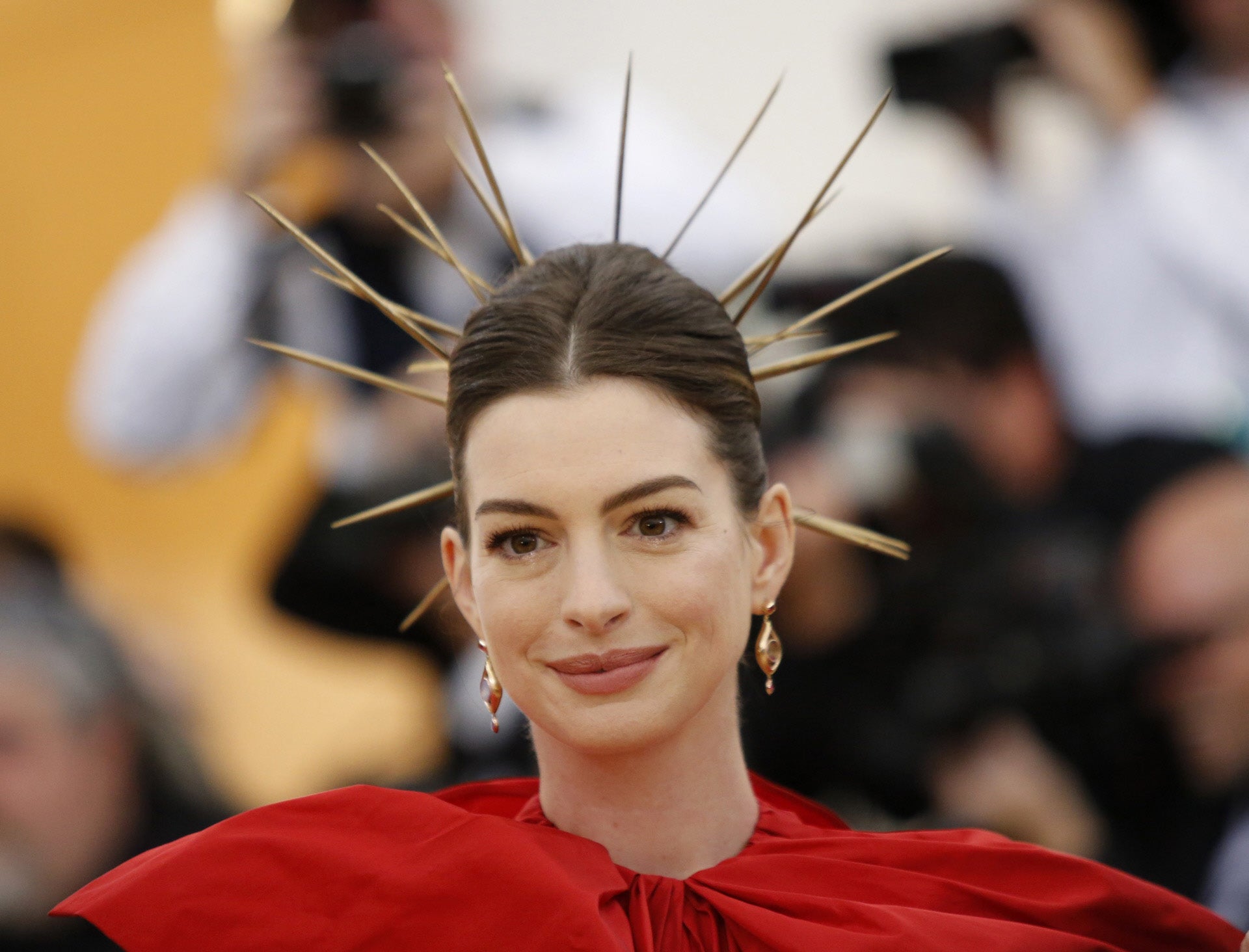 Anne Hathaway recogió su cabello en un moño italiano que adornó con espinas doradas.