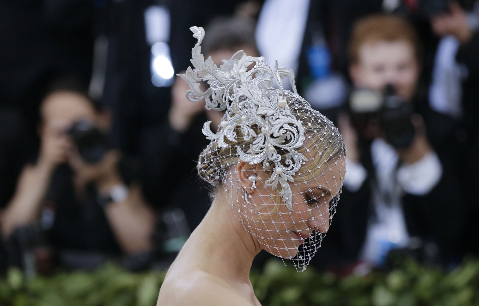 Diane Kruger ha cubierto su cabeza con un velo de rejilla blanco y con piedras, adornado con una especie de flor de tela. Debajo vemos que como peinado la actriz se ha decantado por un moño bajo trenzado.