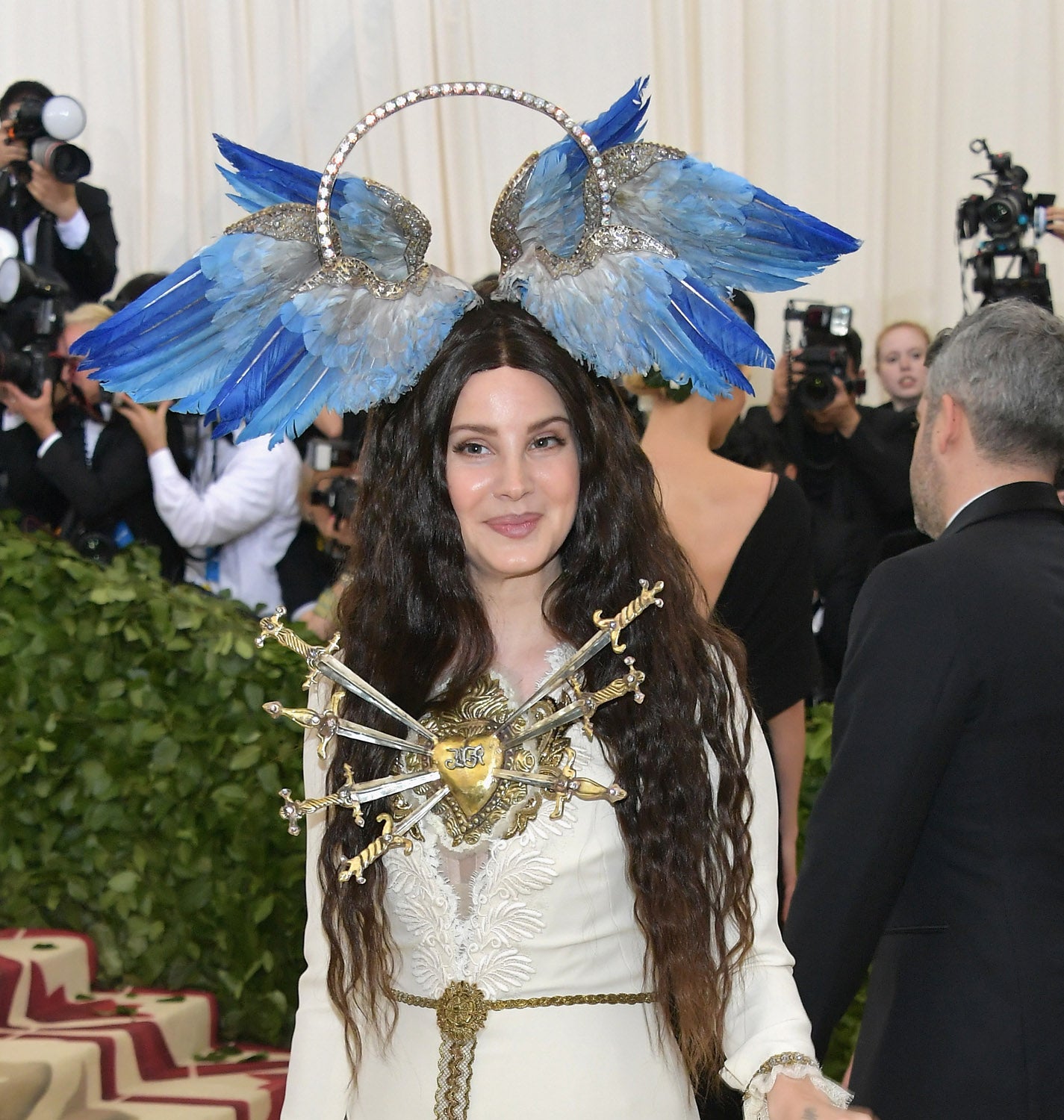 Otro de los tocados más excéntricos de la  alfombra roja de la gala Met  ha sido el de Lana del Rey. Acompañando a uno de los vestidos más llamativos, la actriz ha lucido melena suelta ondulada coronada por unas alas azules.
