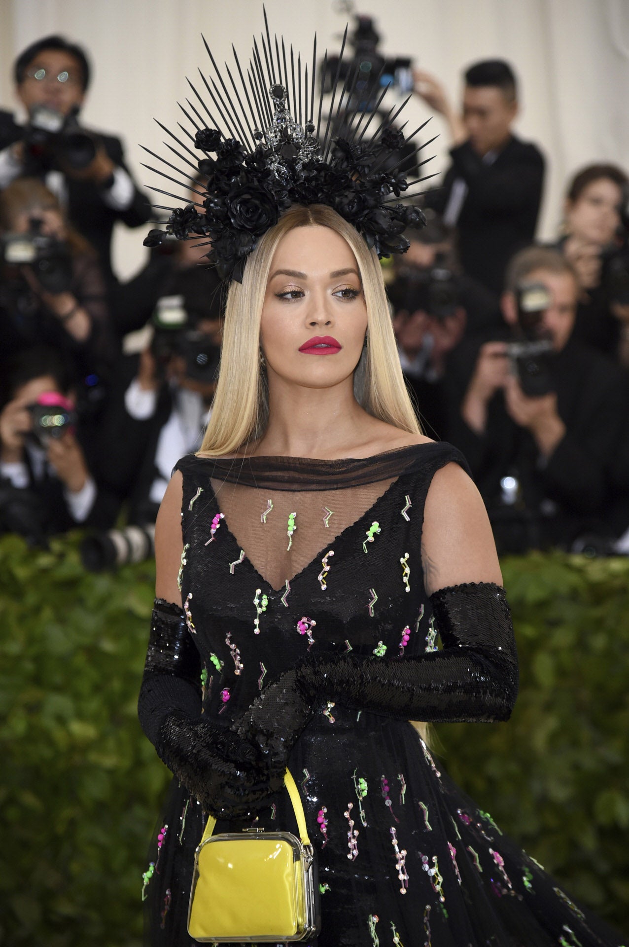 La cantante Rita Ora ha elegido una corona de espinas en color negro con flores, que ha lucido con su melena lisa.
