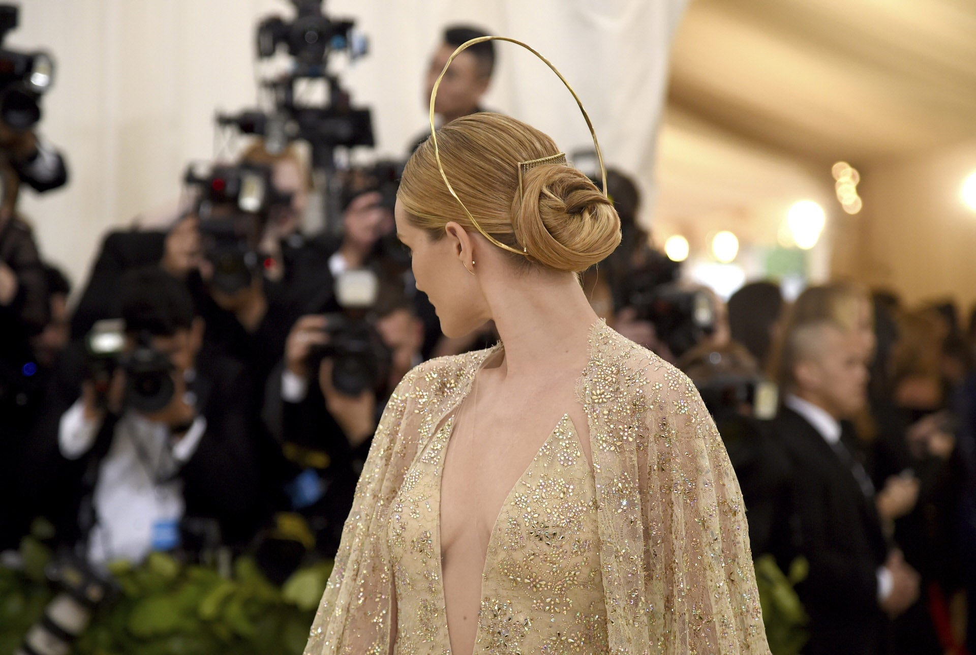 La modelo Rosie Huntington Whiteley ha lucido un moño pulido con raya en el medio, bajo y tipo donut, adornado con un original tocado.