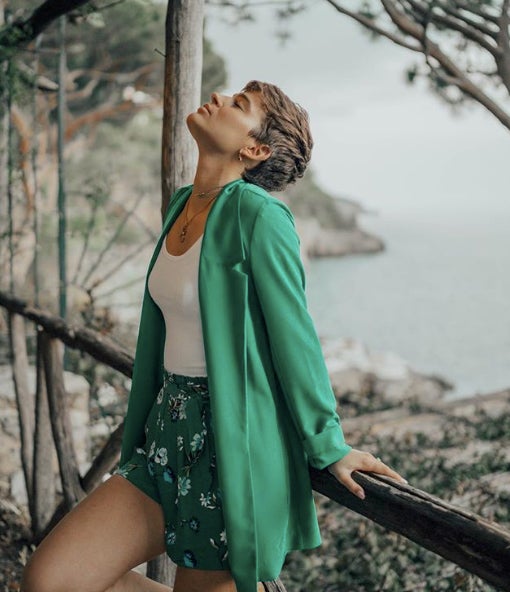 ¿Sabías que el verde es uno de los colores de esta temporada? Pues sí, casi todas las firmas tienen una americana de este color y la puedes combinar con lo que más te apetezca. En este caso la influencer ha elegido unos shorts fluidos estampados (de Stradivarius) y un top blanco.