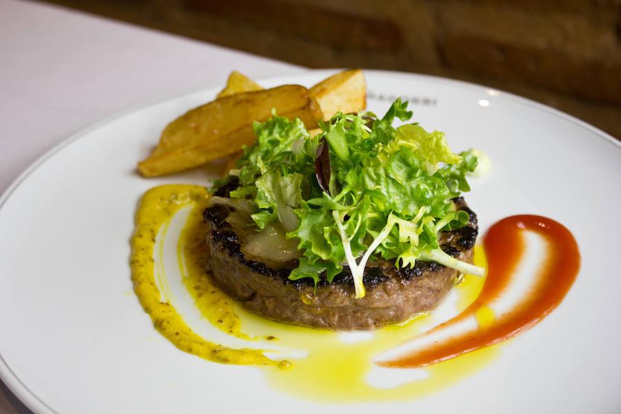 En la calle Padilla, 56, el restaurante de cocina vasco-navarra Muñagorri tiene siempre en carta este plato en versión gourmet: hamburguesa de vaca glaseada al Bourbon, queso brie, cebolla confitada, lechuga y patatas fritas.