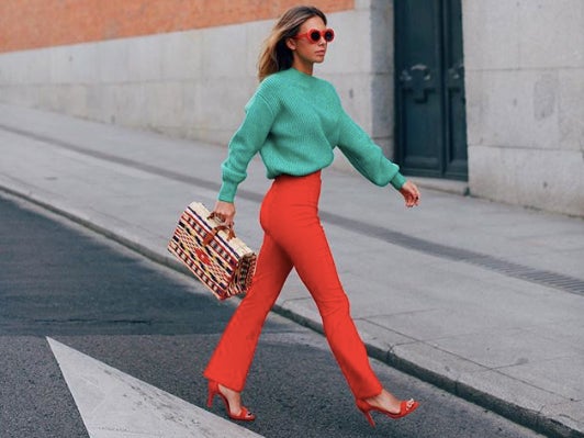 La influencer Lucia Barcena con pantalones largo en color rojo. Déjate llevar por estas ideas para añadir los pantalones en tus looks más fresquitos.
