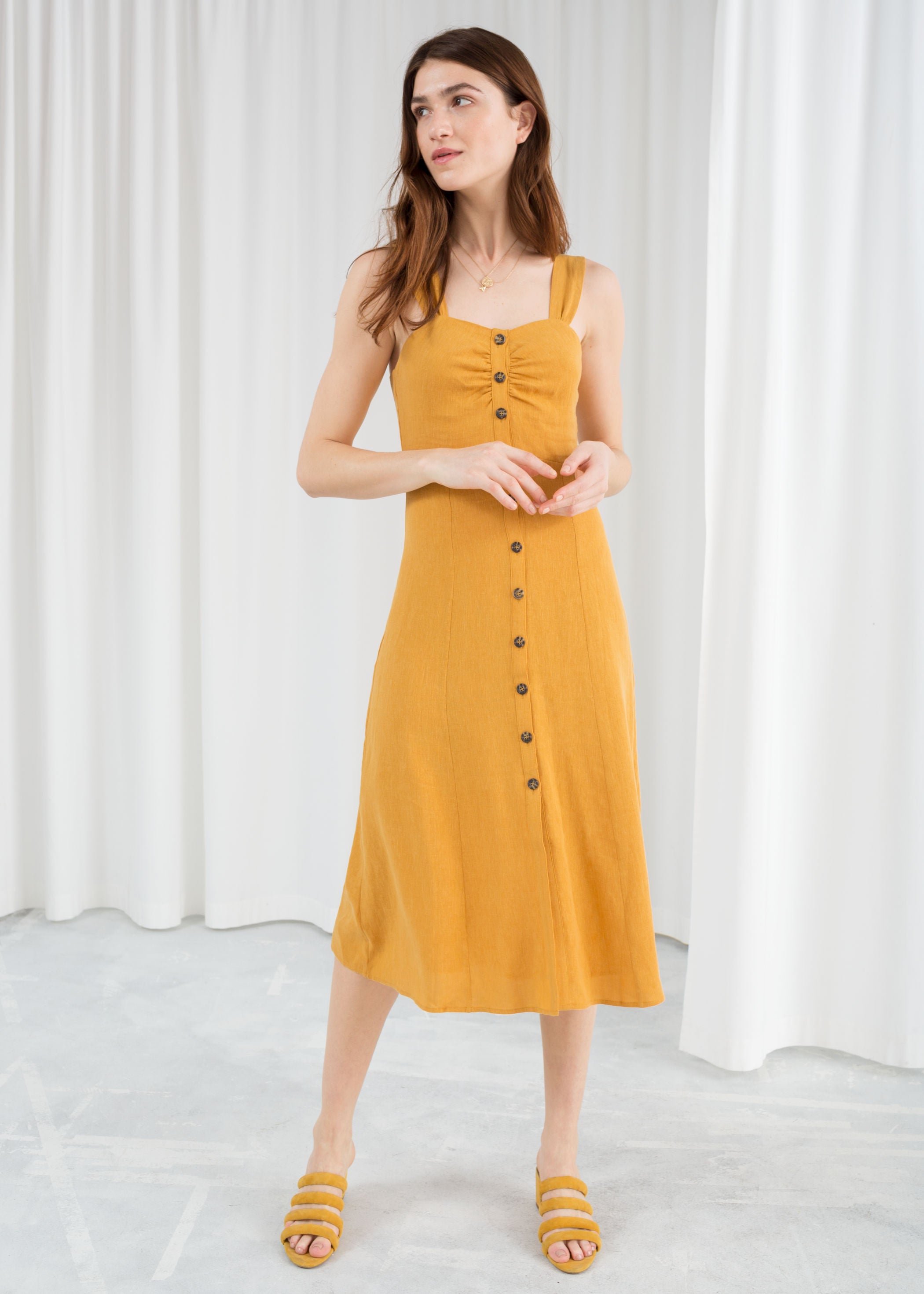 En color mostaza, con cuerpo fruncido y botones de madera, de &Other Stories (69 euros).