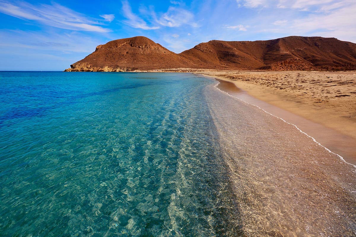 En el top número uno situamos la playa de Los Genoveses, en el Parque Natural de Cabo de Gata (Almería). Una playa virgen, de arena dorada y fina, con agua color turquesa, sin carreteras, sin construcciones, sin chiringuitos ni ruidos que rompan con la magia del silencio. Perfecta para ese viaje espiritual que estás planeando.